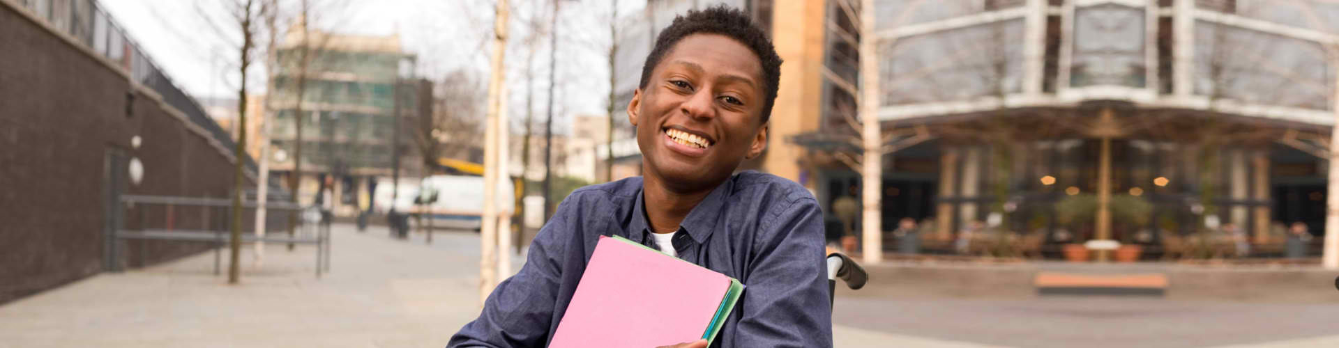 boy with disability holding books